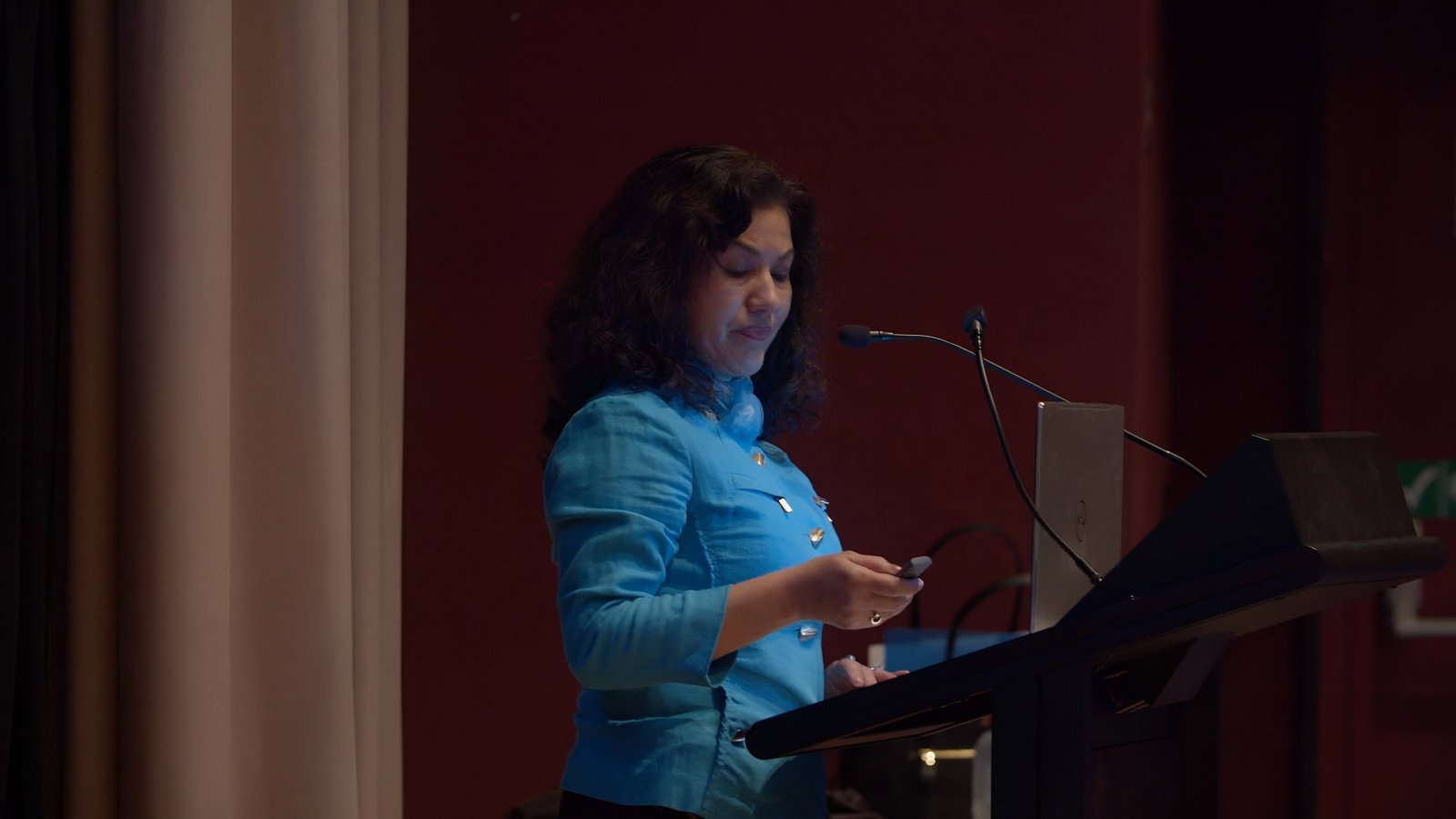 Rushan Abbas speaking at a podium